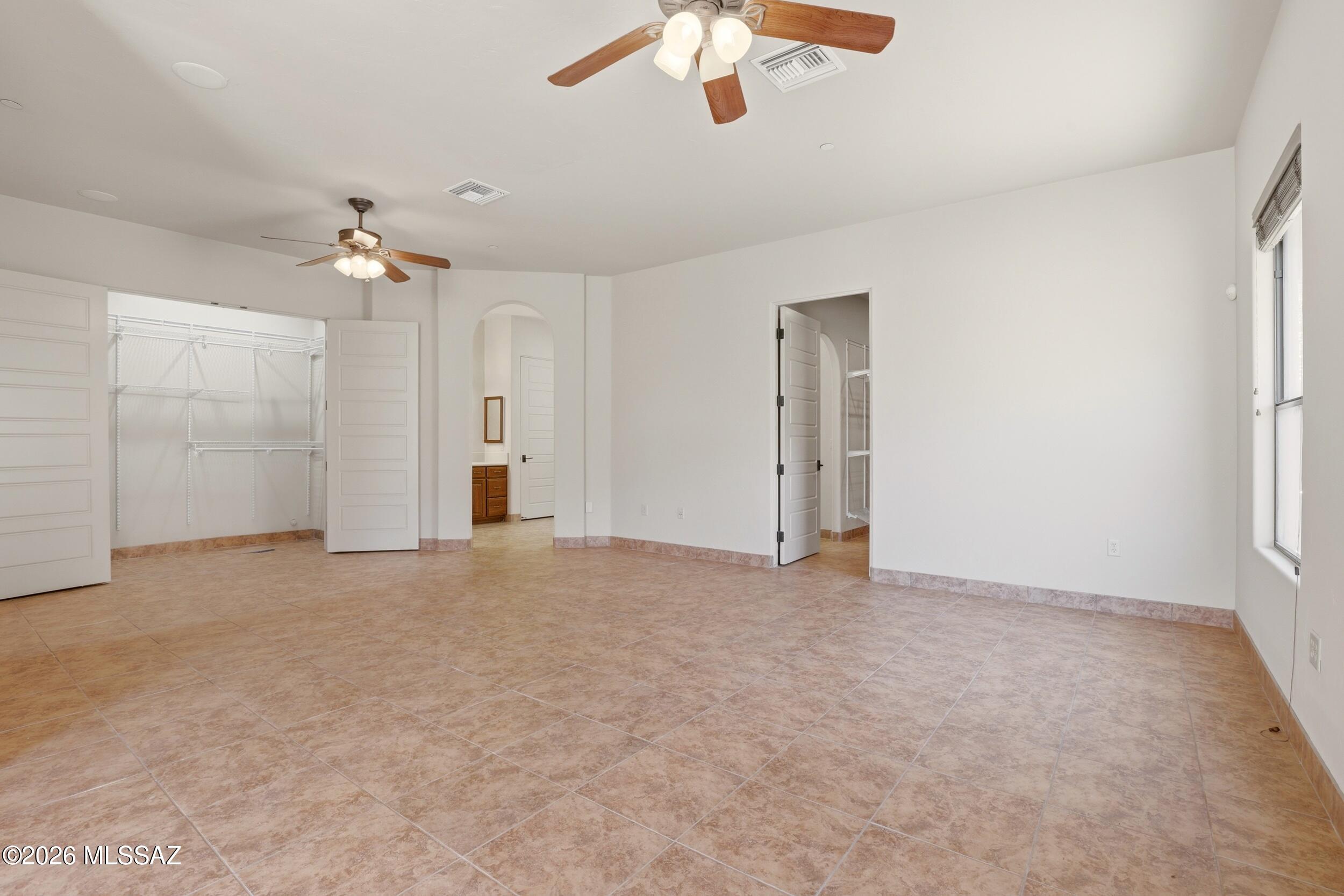 6331 West Trails End Road Tucson, AZ 85745 - Photo 13 of 41 an empty room with chandelier fan and windows
