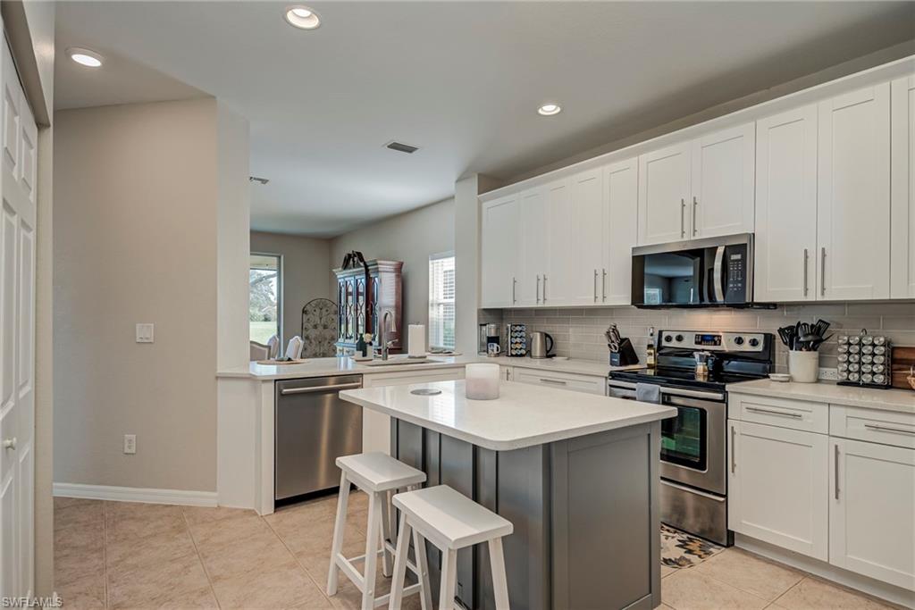 1897 Par Drive Naples, FL 34120 - Photo 11 of 31 a kitchen with a sink a stove a refrigerator and white cabinets