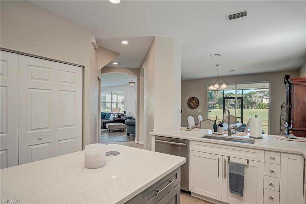 1897 Par Drive Naples, FL 34120 - Photo 12 of 31 a kitchen with a sink and dishwasher with white cabinets