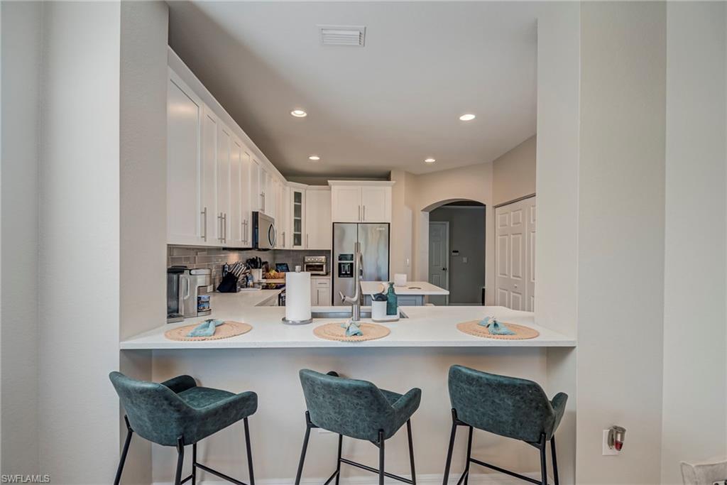 1897 Par Drive Naples, FL 34120 - Photo 9 of 31 a kitchen with a dining table cabinets and chairs