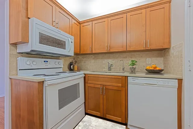 a kitchen with stainless steel appliances granite countertop a sink stove and cabinets