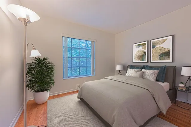 a bedroom with a large bed and a potted plant