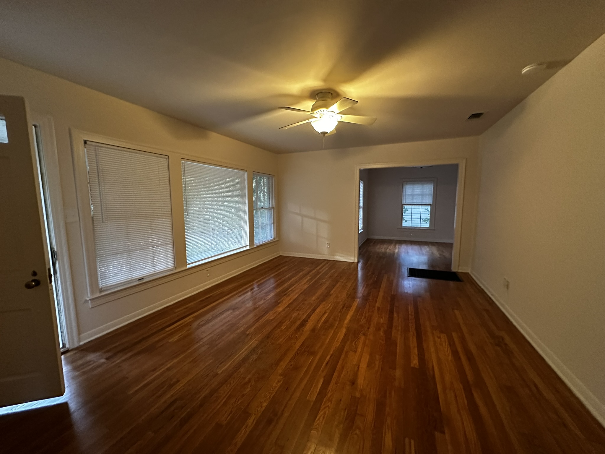 Rich hardwood floors sweep through this versatile living space illuminated by multiple windows.