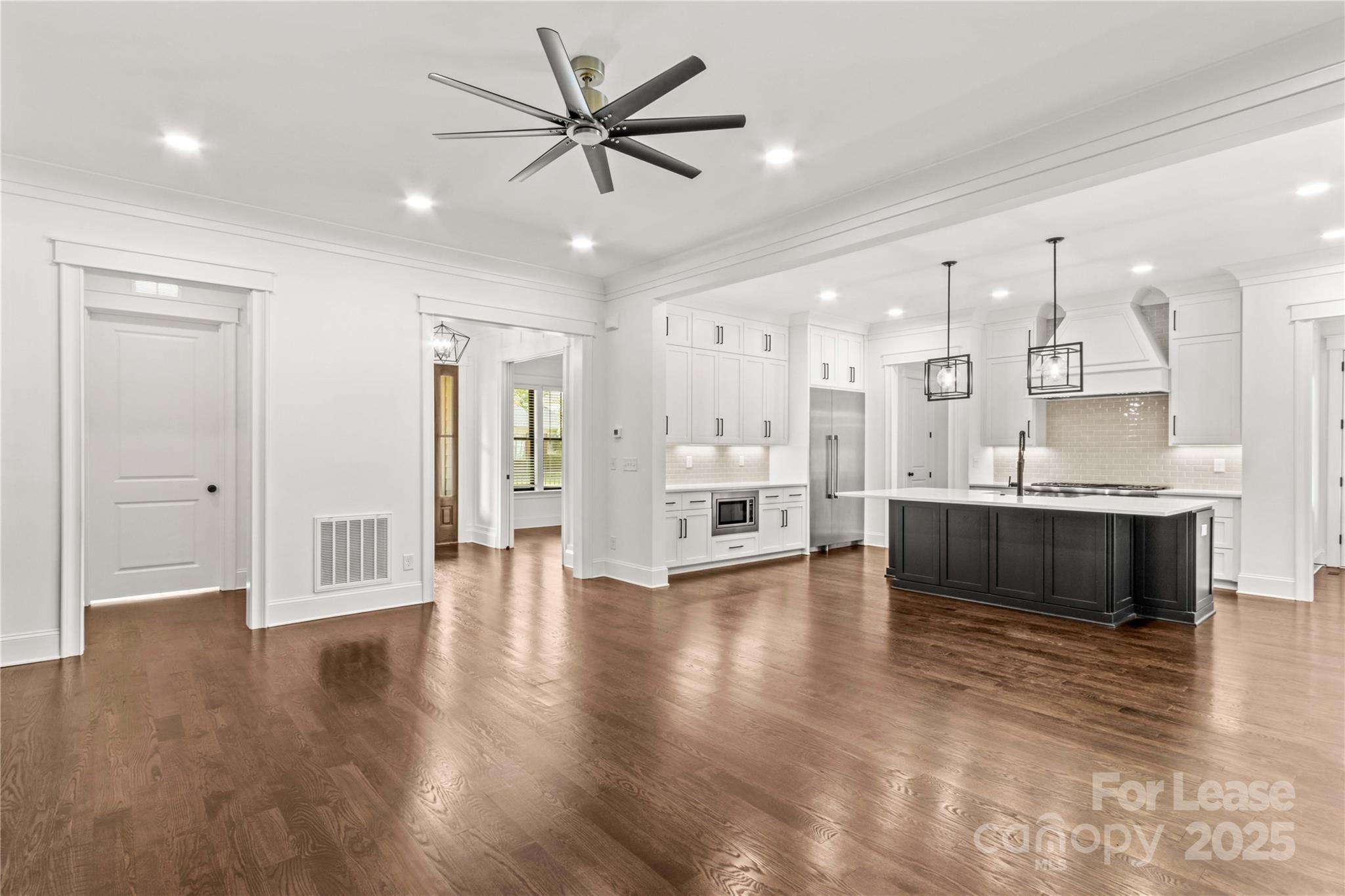 269 Conroy Avenue Davidson, NC 28036 - Photo 18 of 48 a view of an empty room and kitchen with wooden floor
