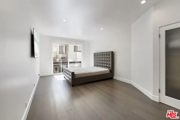 a spacious bedroom with a bed and a dresser