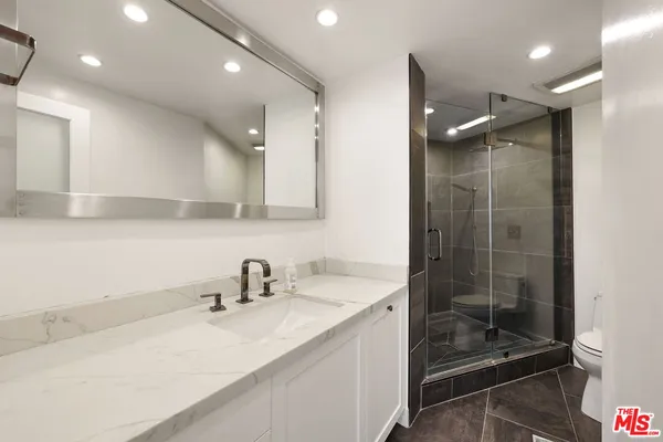 a bathroom with a bathtub shower sink vanity and toilet