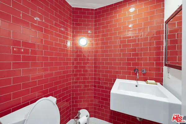 a kitchen with a stove a sink and wooden floor