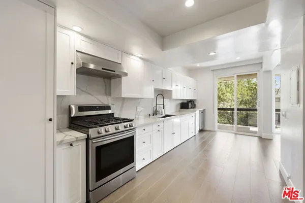 a kitchen with granite countertop a stove and a wooden floors