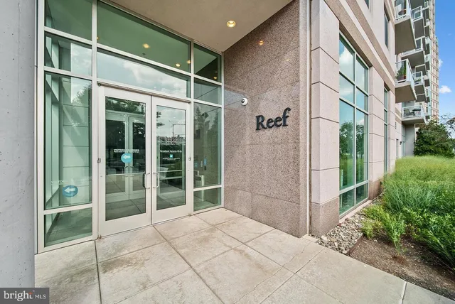 a living room with couches a flat screen tv and kitchen view