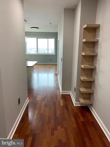 a kitchen with kitchen island granite countertop a refrigerator a oven a sink and white cabinets with wooden floor