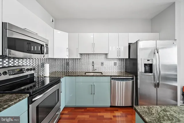 a kitchen with granite countertop a sink and refrigerator