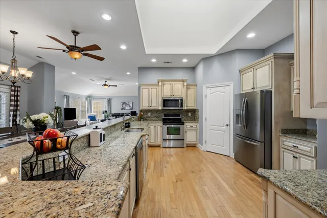 a kitchen with stainless steel appliances kitchen island granite countertop a refrigerator and microwave