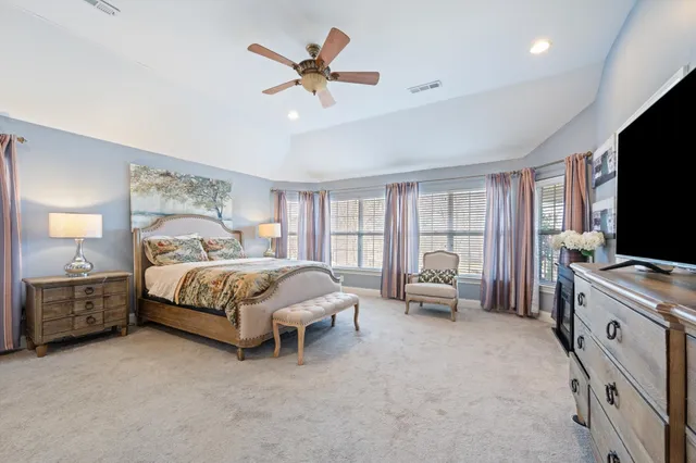 a bedroom with a bed and a flat tv screen on dresser
