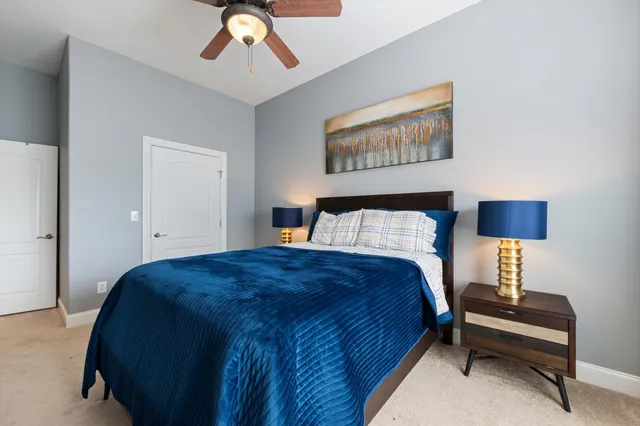 a bedroom with a bed and a lamp on dresser