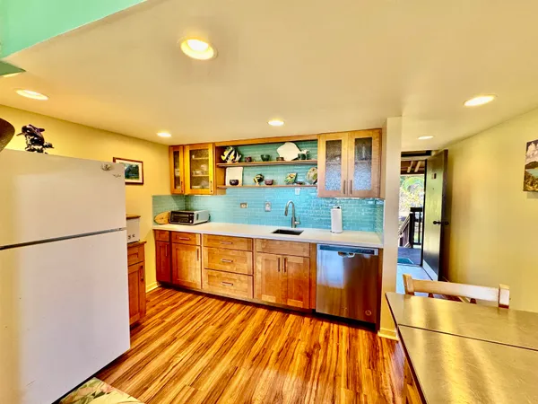 a kitchen with a refrigerator and wooden floor