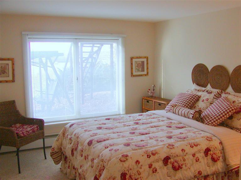 168 Holly Point Road Centerville, MA 02632 - Photo 26 of 28 a bedroom with a bed and wooden floor