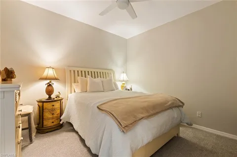 a bedroom with a bed and a lamp on the dresser