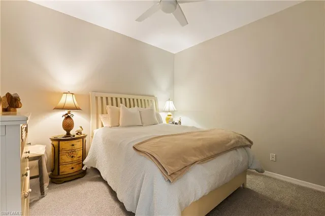 a bedroom with a bed and a lamp on the dresser