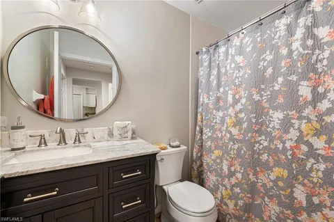 a bathroom with a granite countertop sink a toilet and a mirror