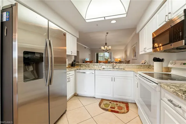 a kitchen with a sink stainless steel appliances and white cabinets