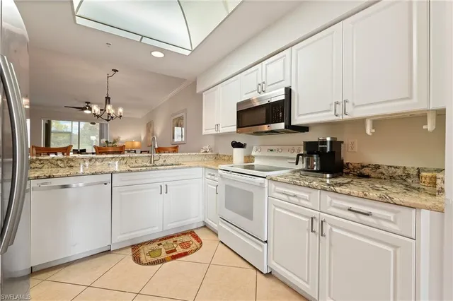 a kitchen with white cabinets appliances and a sink