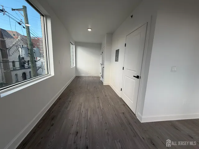 a view of a hallway with wooden floor and a window