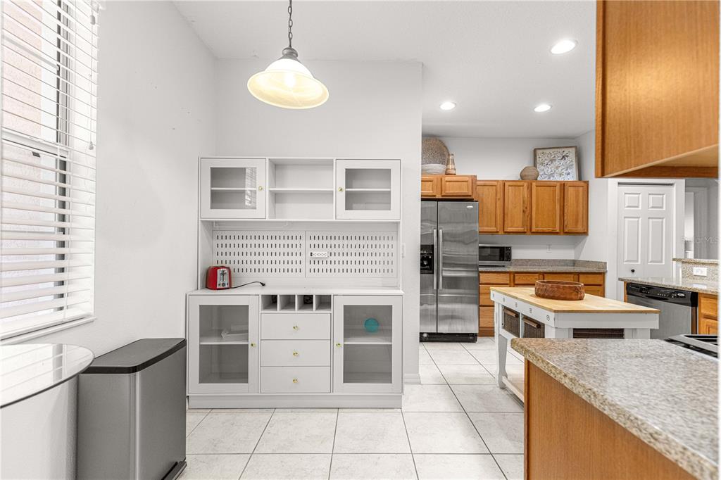 9317 Southwest 94th Loop Ocala, FL 34481 - Photo 15 of 40 a kitchen with stainless steel appliances granite countertop a stove top oven a sink and a refrigerator