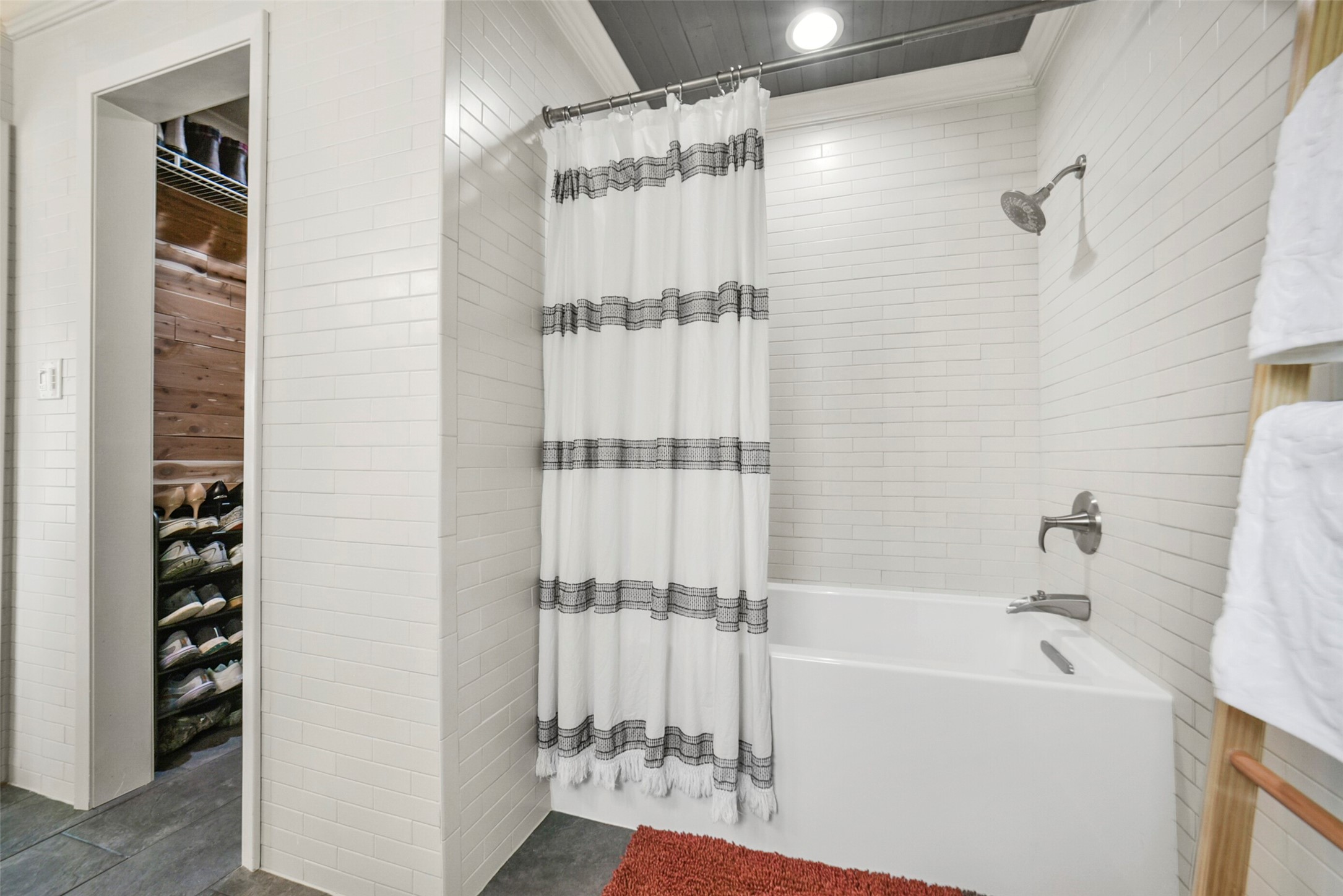 10313 South Williams Road Conroe, TX 77303 - Photo 26 of 48 Primary bathroom and closet. Gorgeous tile work throughout bathroom.