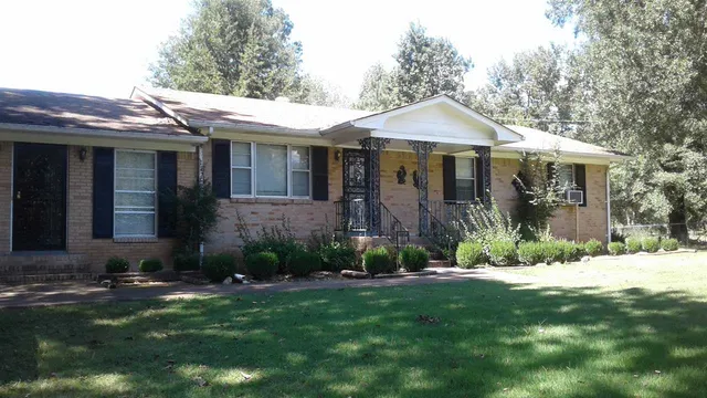 a front view of a house with a yard and potted plants
