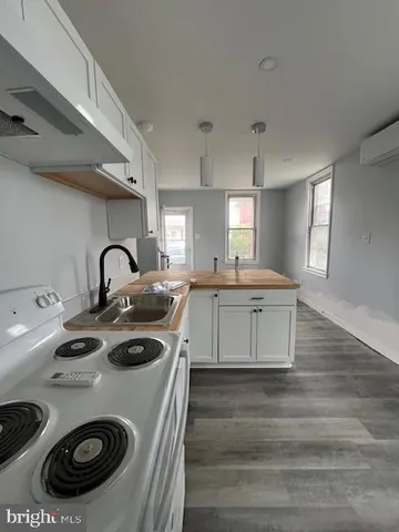 a kitchen with a sink a stove and cabinets
