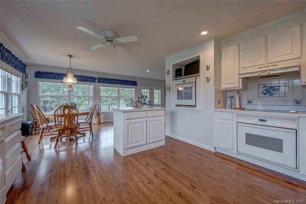 404 Loray Farm Road Dallas, NC 28034 - Photo 12 of 23 a kitchen with a table chairs refrigerator and cabinets
