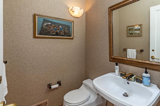 a bathroom with a toilet sink and mirror