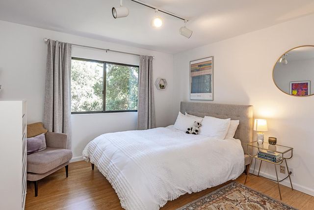 a bedroom with a bed and wooden floor