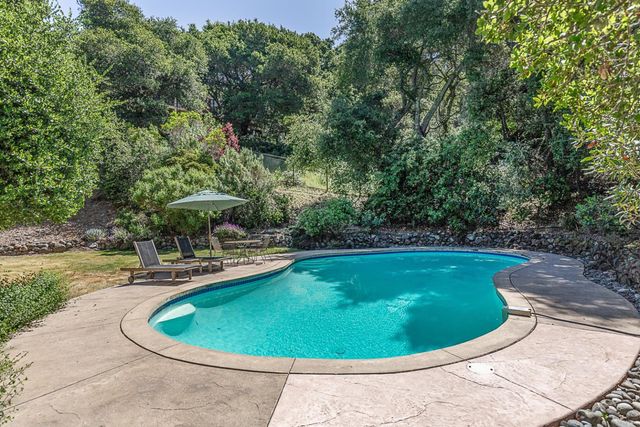 a view of a swimming pool in back of the house