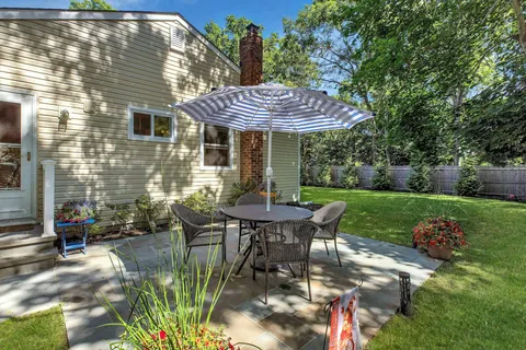 a view of a table and chairs in back yard of a house