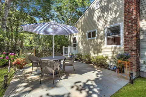 a patio with a table and chairs under an umbrella