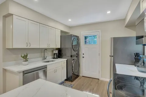 a kitchen with a sink cabinets and wooden floor