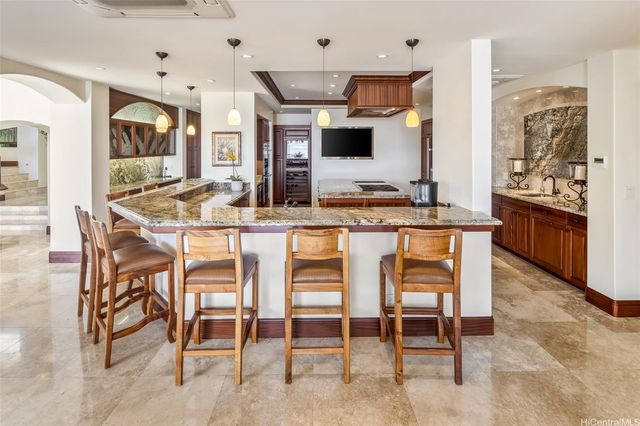a kitchen with stainless steel appliances kitchen island granite countertop a table and chairs in it