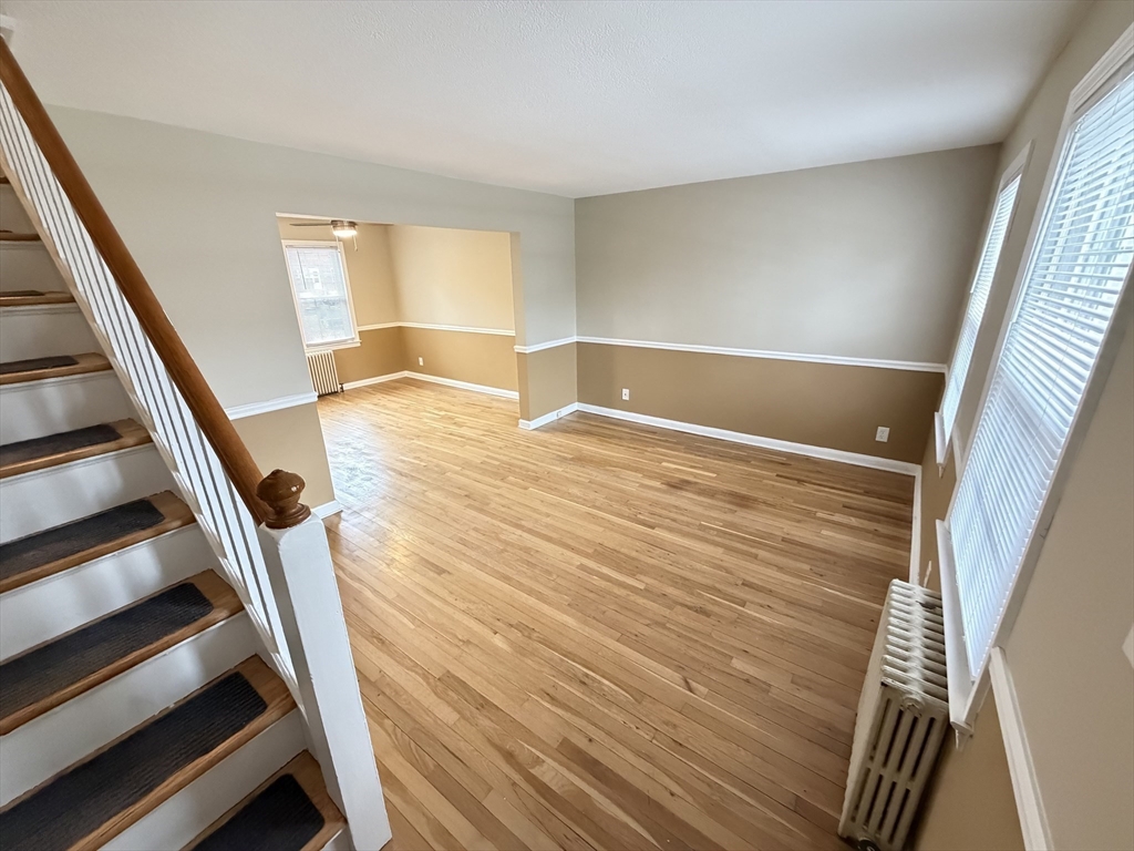 474 Cold Spring Avenue, Unit 474 West Springfield, MA 01089 - Photo 11 of 22 a view of an empty room with wooden floor and stairs