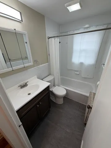 a bathroom with a sink a toilet a mirror and a glass door shower