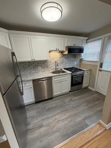 a kitchen with stainless steel appliances granite countertop a sink a stove and a refrigerator