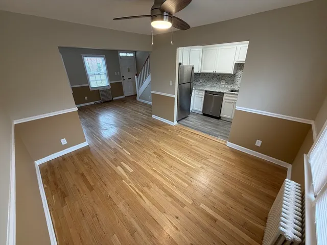 an empty room with a fireplace and wooden floor