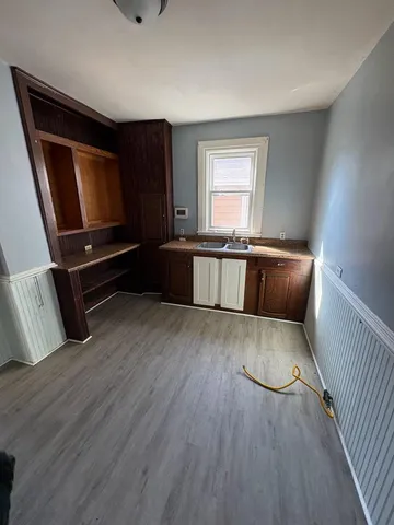 a living room with stainless steel appliances furniture a window and wooden floor