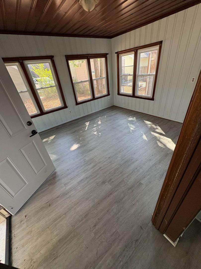 1512 West Millman Street Peoria, IL 61605 - Photo 8 of 9 a view of an empty room with wooden floor and windows