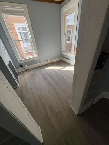 a view of a livingroom with wooden floor and a window