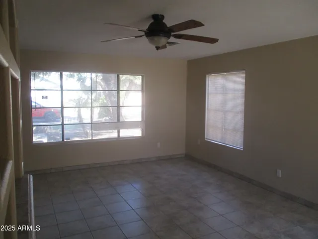 a view of an empty room and window chandelier fan