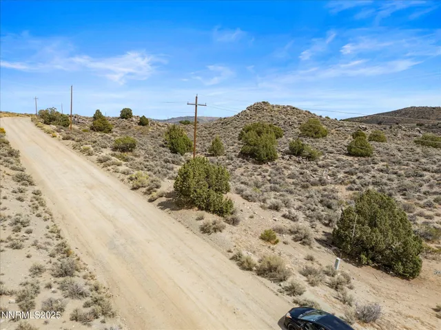 a view of a dry field with a view of mountains