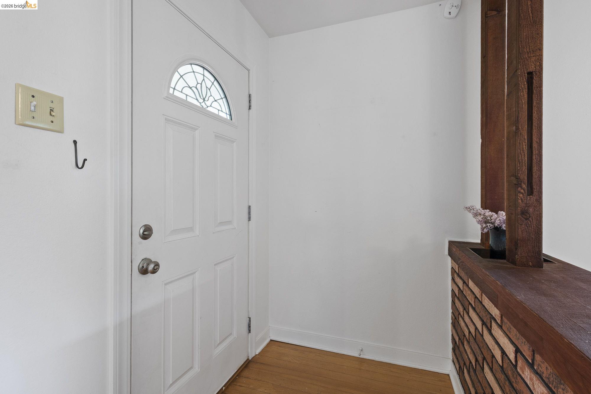 18363 Yosemite Road Tuolumne, CA 95379 - Photo 2 of 34 White entry door with decorative glass insert, complemented by wood-finish flooring