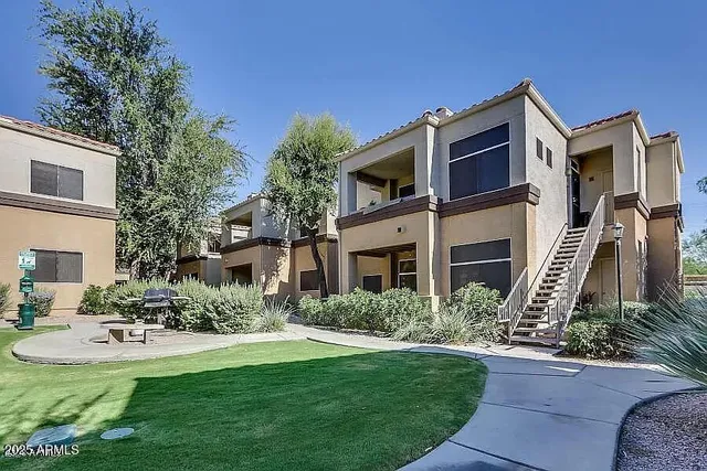 a front view of a house with garden and trees