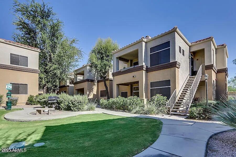 a front view of a house with garden and trees